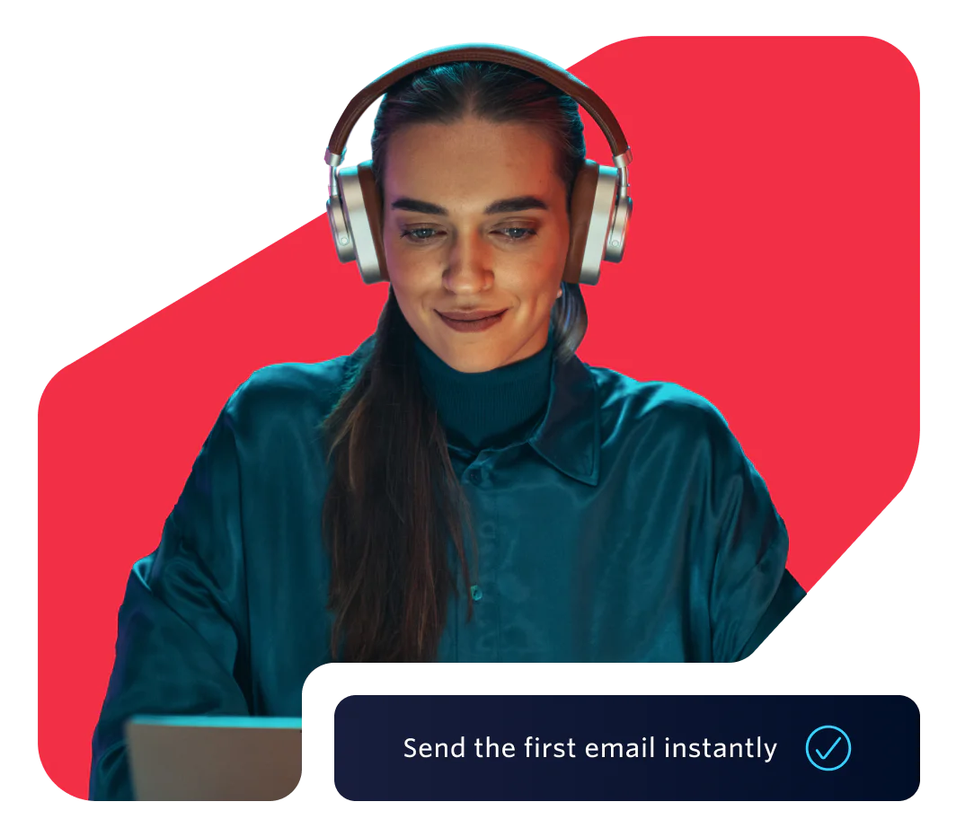 Woman wearing headphones working on her laptop Woman in headphones using a laptop with a prompt to send the first email instantly
