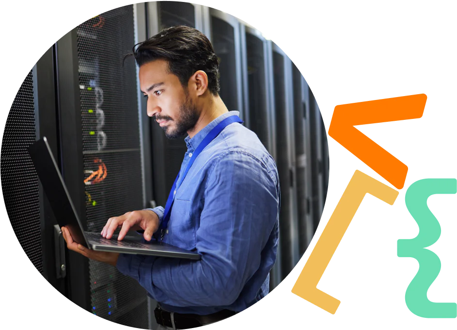 IT Professional Managing Server Infrastructure Man working on a laptop in a server room with server racks in the background